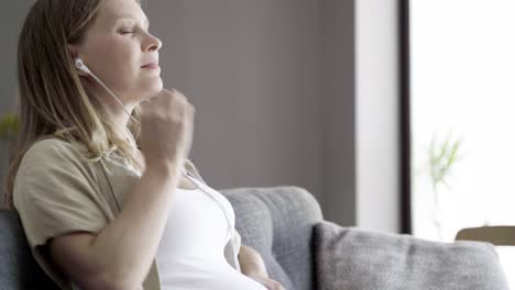 Ruhige-Schwangere-Frau-Massiert-Bauch-Und-Hört-Musik